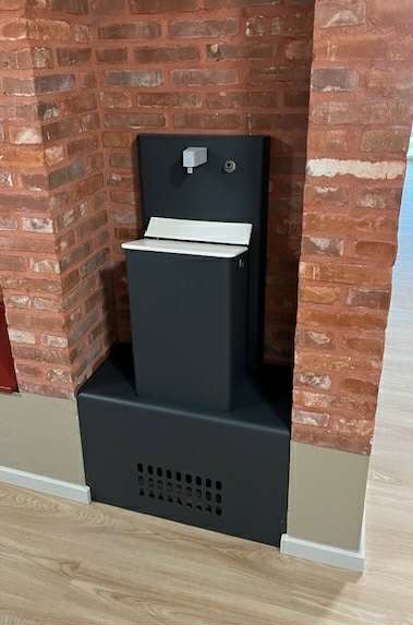 Moderne vandfontæne mellem murstensvægge